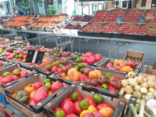 un marché avec de nombreuses boîtes de fruits et légumes dans l'établissement Une heureuse coïncidence, à Montpellier