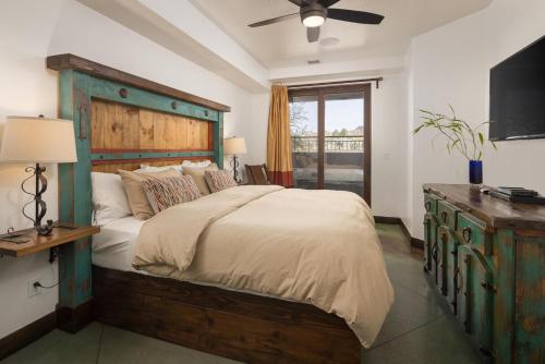 a bedroom with a large bed with a wooden headboard at La Dolce Vita Villas 10 in Moab