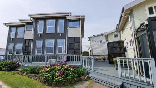 a house with a white fence and some flowers at Haumok52 Udo in Jeju