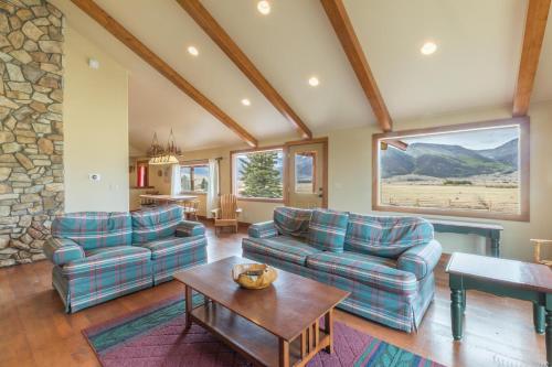 a living room with two couches and a table at Meadow View Cabin in Creede