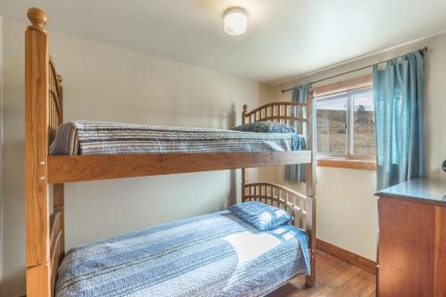 two bunk beds in a room with a window at Meadow View Cabin in Creede