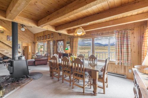 a dining room with a table and chairs and a fireplace at Charming Starlight Cabin in Creede