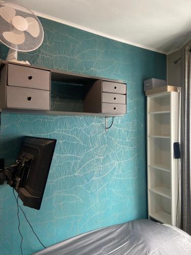 - une chambre dotée d'un mur bleu avec un lit et un lavabo dans l'établissement Cosy studio Paris 16 métro Exelmans, à Paris