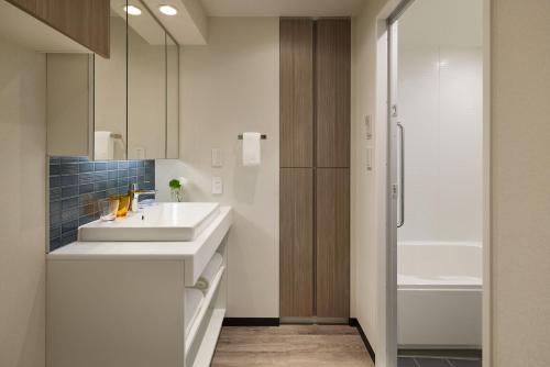 a bathroom with a sink and a shower at Oakwood Hotel & Apartments Azabu Tokyo in Tokyo