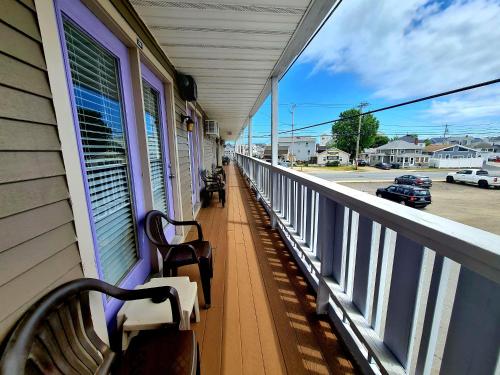 a porch with benches on a building with a view of a street at Regal Inn Hampton Beach in Hampton