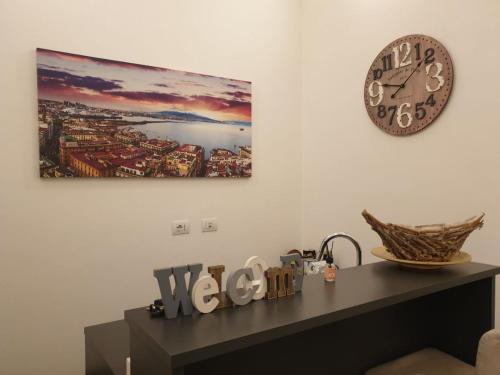 a clock on a wall next to a table with a clock at Napoli Belle Arti in Naples