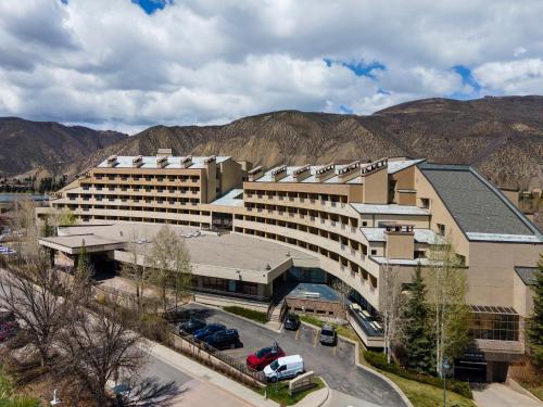 a large building with a parking lot in front of mountains at The Seasons Unit 205 in Avon