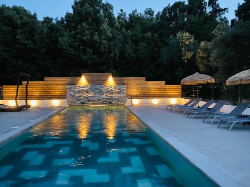 a swimming pool with lounge chairs and a fireplace at Gite U Licetu A la Campagne in Oreta