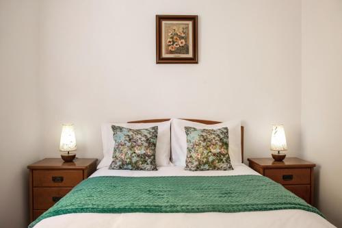 um quarto com uma cama com duas mesas de cabeceira em Alecrim Beach House em Nazaré