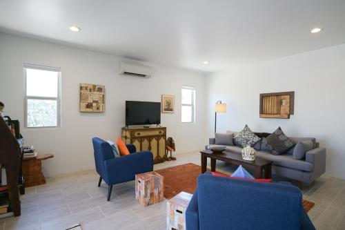 a living room with a couch and chairs and a television at Casa Vitalia in Santa Fe