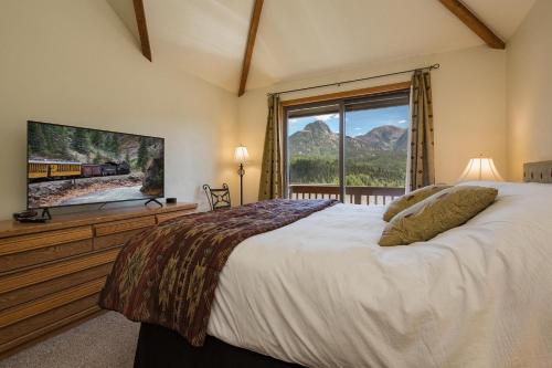 ein Schlafzimmer mit einem großen Bett und einem großen Fenster in der Unterkunft Cascade Village 59 in Durango Mountain Resort