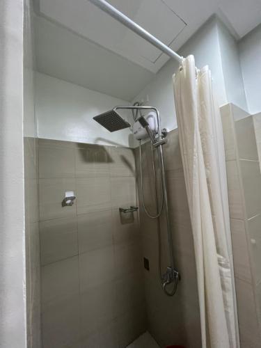 a bathroom with a shower with a shower curtain at S Shore in Manila