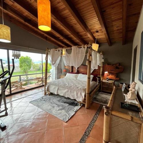 um quarto com uma cama de dossel e uma varanda em Casa Valle Horus em Valle de Bravo