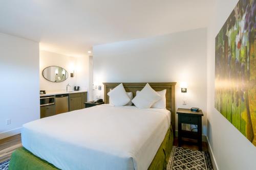a bedroom with a large white bed and a sink at The Inn on Pine in Calistoga