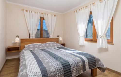 ein Schlafzimmer mit einem Bett und zwei Fenstern in der Unterkunft Stunning Home In Rakovicko Seliste With Kitchen in Selište
