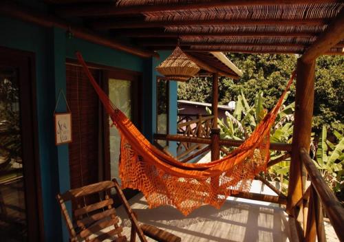 a hammock on the porch of a house at Casa Mabuia Beach in Barra Grande