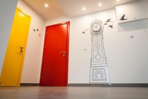 a clock on a wall next to two doors at Vila Nikolas in Druskininkai