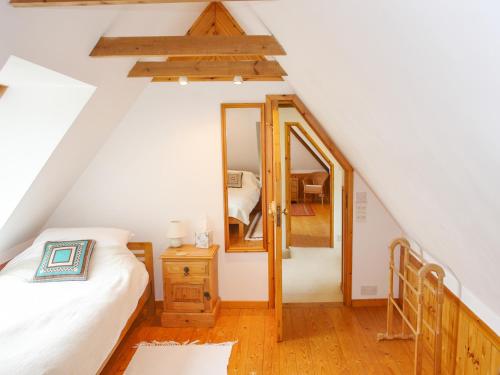 a attic bedroom with a bed and a mirror at The Old Forge in Newton Abbot
