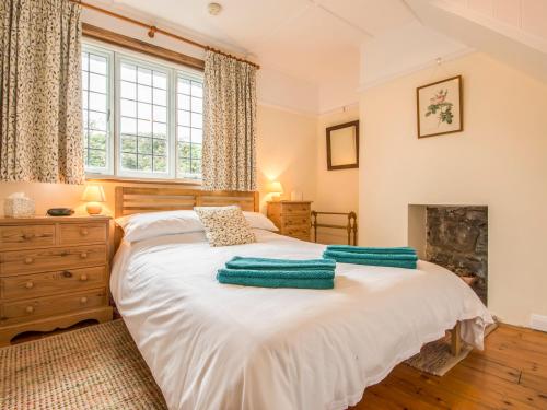 a bedroom with a bed with green towels on it at The Old Forge in Newton Abbot