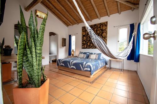 a bedroom with a hammock in a room with a bed at Casa Mediterránea Villa de Leyva in Villa de Leyva