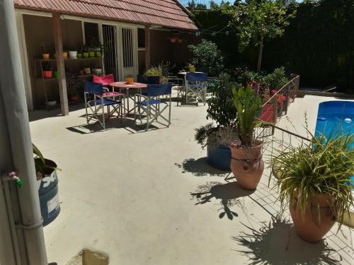a patio with chairs and tables and potted plants at El Jacal de San Pedro in San Pedro