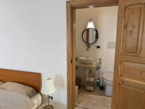 een slaapkamer met een bed, een spiegel en een wastafel bij Casa Mignano in Gallipoli