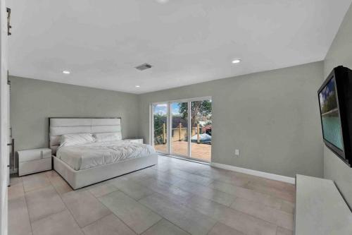 um quarto com uma cama e uma televisão de ecrã plano em Luxurious 5 bedroom lake house 3min from Universal em Orlando