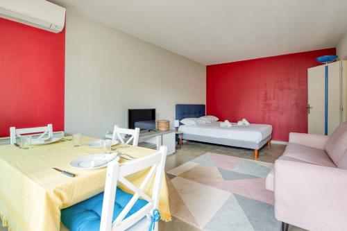 昂蒂布的住宿－Studio Rostagne - Welkeys，一间红色墙壁、一张桌子和一张床的房间