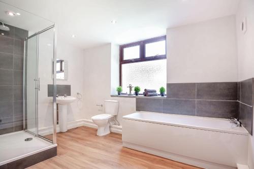 a bathroom with a tub and a toilet and a sink at Stiniog Lodge in Blaenau-Ffestiniog