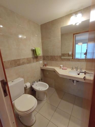 a bathroom with a toilet and a sink and a mirror at Hermoso Departamento 2 amb con cochera en Plaza Mitre in Mar del Plata