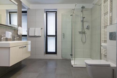 uma casa de banho com um chuveiro, um WC e um lavatório. em La Pension em Trnava