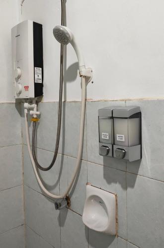 a shower in a bathroom with a dispenser on a wall at Apartment Next to Unifi Arena Axiata, Stadium Bukit Jalil in Kuala Lumpur