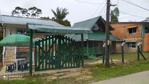 a building with a green cover in front of a house at VIDAMAR, JUANCHACO. LADRILLEROS, LA BARRA in Playa Ladrilleros