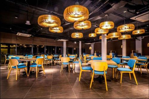 un comedor con mesas, sillas y lámparas de araña en Oceanami Resort & Beach Club, en Long Hai