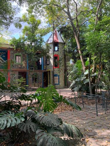 a small house in the middle of a garden at Hotel La Casa de los Árboles Immersive Experience in Zacualpan de Amilpas