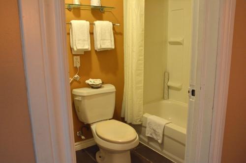 uma casa de banho com um WC branco e uma banheira em Bracebridge Inn em Bracebridge