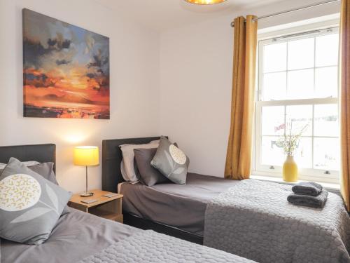 een slaapkamer met 2 bedden en een raam bij The Nook in Inverness