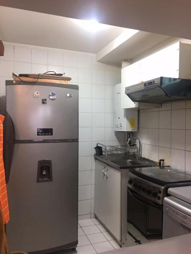 a kitchen with a stainless steel refrigerator and a stove at DEPARTAMENTOS TERMAS DE CHILLAN in Nevados de Chillan
