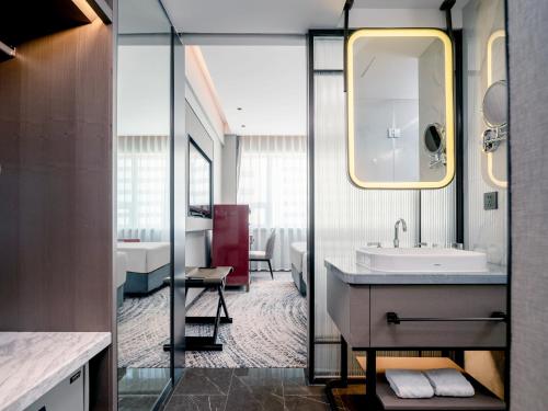 深セン市にあるShenzhen Shanghai Hotelの洗面台と鏡のあるバスルーム