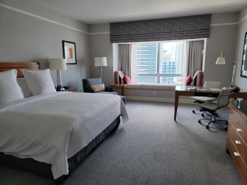 a hotel room with a bed and a desk and a window at Four Seasons Private Studio Unit in Miami