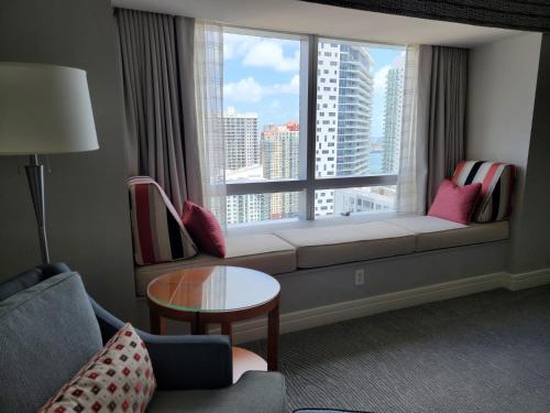 a living room with a window with a couch and a table at Four Seasons Studio - Privately Owned Unit in Miami