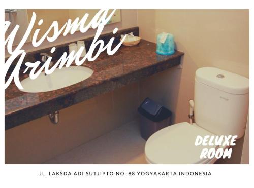 a bathroom with a white toilet and a sink at Wanitatama Villas in Demangan