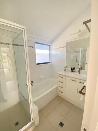 a bathroom with a sink, toilet and bathtub at Glen Eden Beach Resort in Peregian Beach