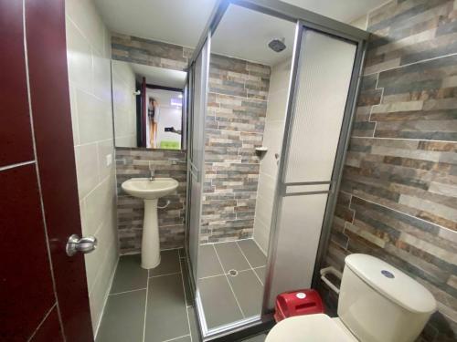 uma casa de banho com um chuveiro, um WC e um lavatório. em Hotel Dubai Suite em Pasto