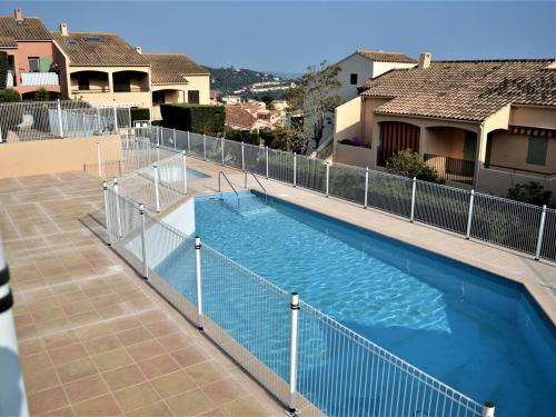 une piscine entourée d'une clôture dans l'établissement Appartement Cosy avec Terrasse, Piscine & Parking, Proche Plages – 2 Pièces pour 4 à Cavalaire - FR-1-226B-108, à Cavalaire-sur-Mer