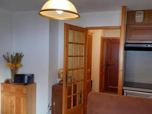 Cette chambre dispose d'une cuisine avec une porte et une lampe. dans l'établissement Spacieux T2 avec WiFi, parking inclus, proche centre Chamonix - FR-1-517-63, à Chamonix-Mont-Blanc
