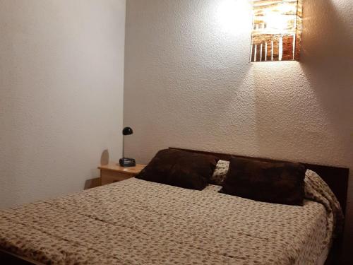 une chambre avec un lit avec deux oreillers dessus dans l'établissement Spacieux T2 avec WiFi, parking inclus, proche centre Chamonix - FR-1-517-63, à Chamonix-Mont-Blanc