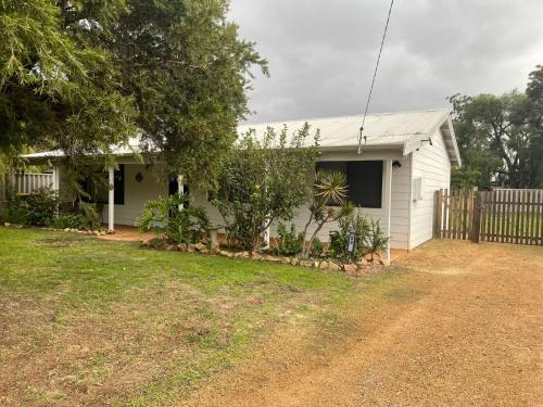 una casa bianca con recinzione e cortile di Menta Cottage a Dunsborough