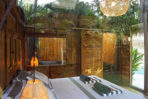 a room with a table and a large window at Musa Bintang Villas and Bungalows Gili Air in Gili Air
