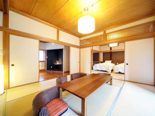 a dining room with a table and two beds at Takanosukan in Sekikawa